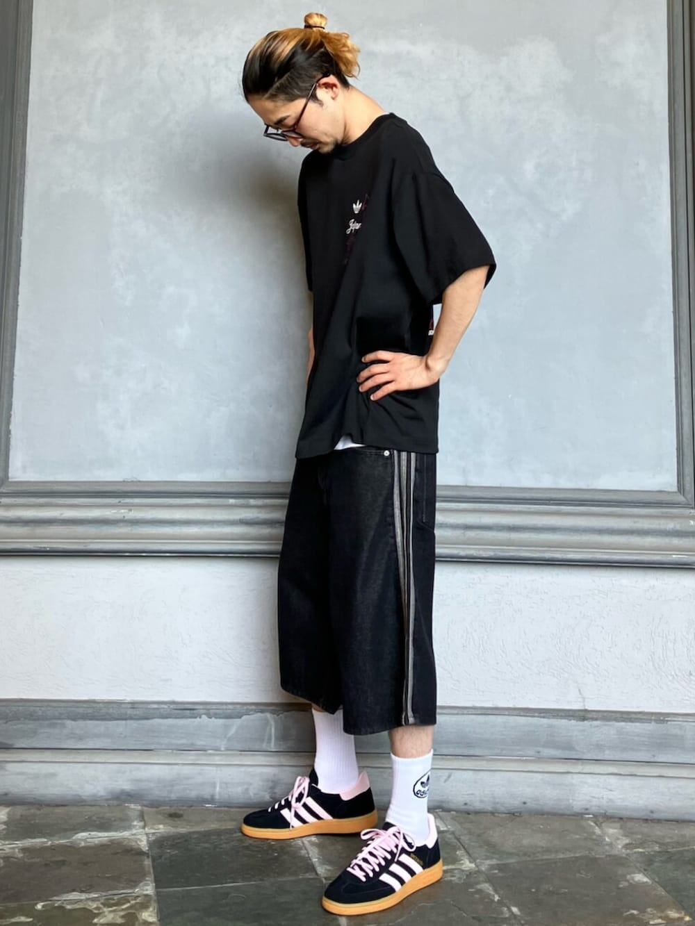 ブラック系のトップス、ブラック系のデニムパンツ、ブラック系のスニーカーを着用したメンズの秋コーディネートの2枚目の写真