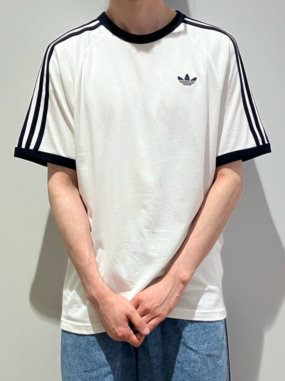 ブラック系のサンダル、ホワイト系のTシャツ/カットソー、ブルー系のデニムパンツを着用したメンズの夏コーディネートの3枚目の写真
