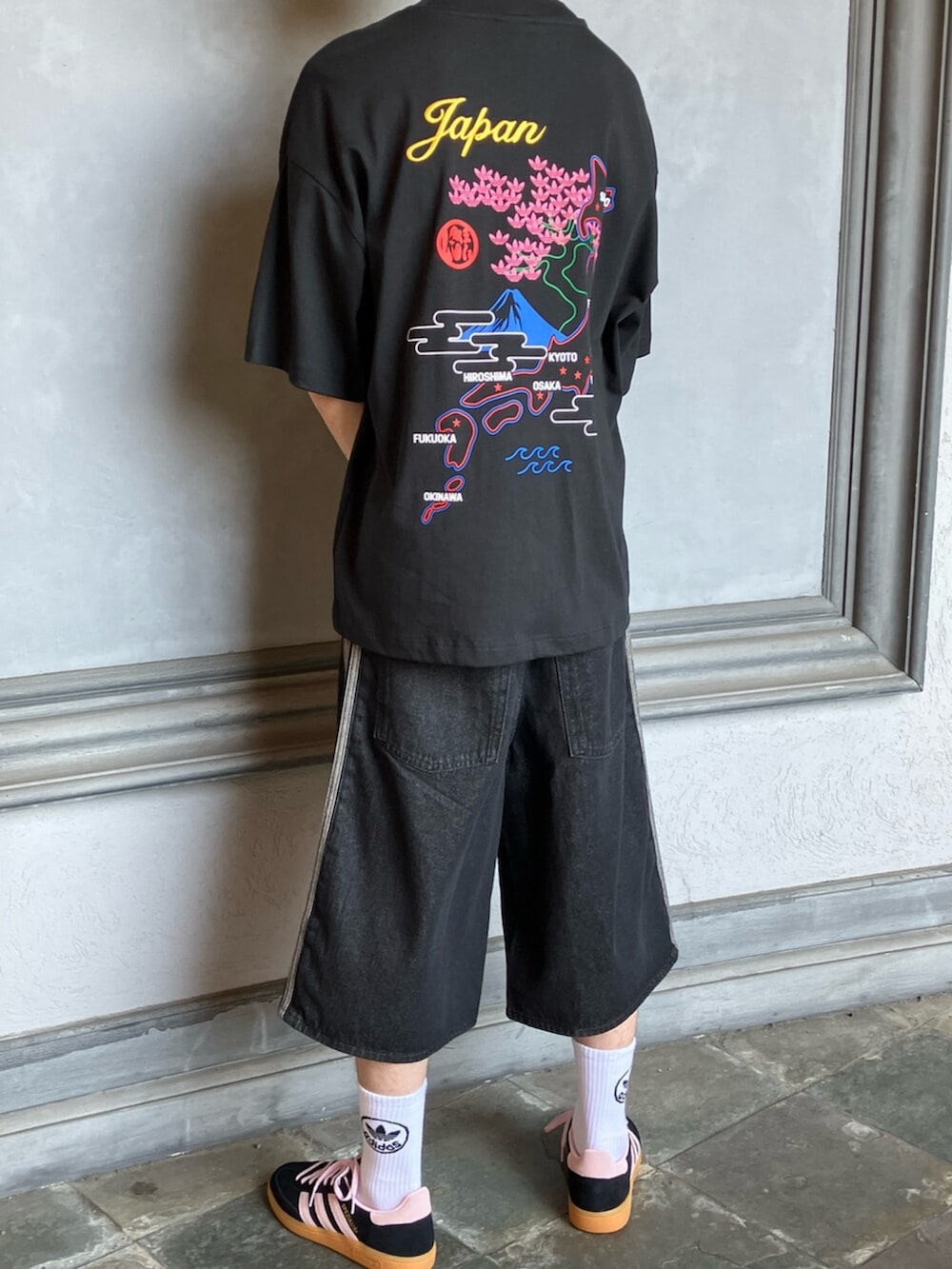 ブラック系のトップス、ブラック系のデニムパンツ、ブラック系のスニーカーを着用したメンズの秋コーディネートの3枚目の写真