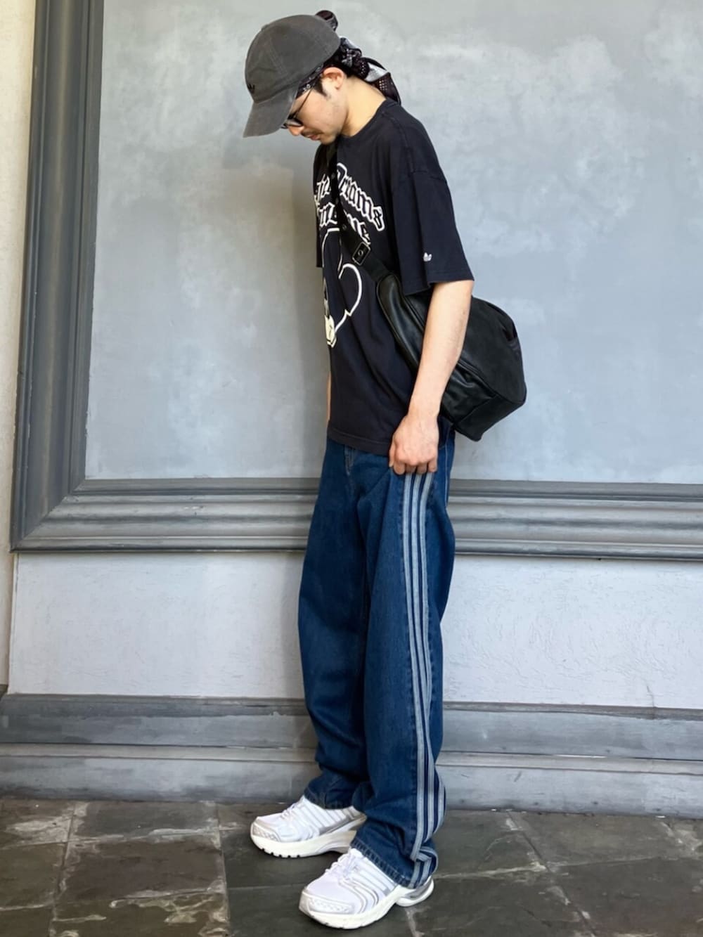 ブラック系のTシャツ/カットソー、ブルー系のデニムパンツ、ホワイト系のシューズを着用したメンズの夏コーディネートの2枚目の写真