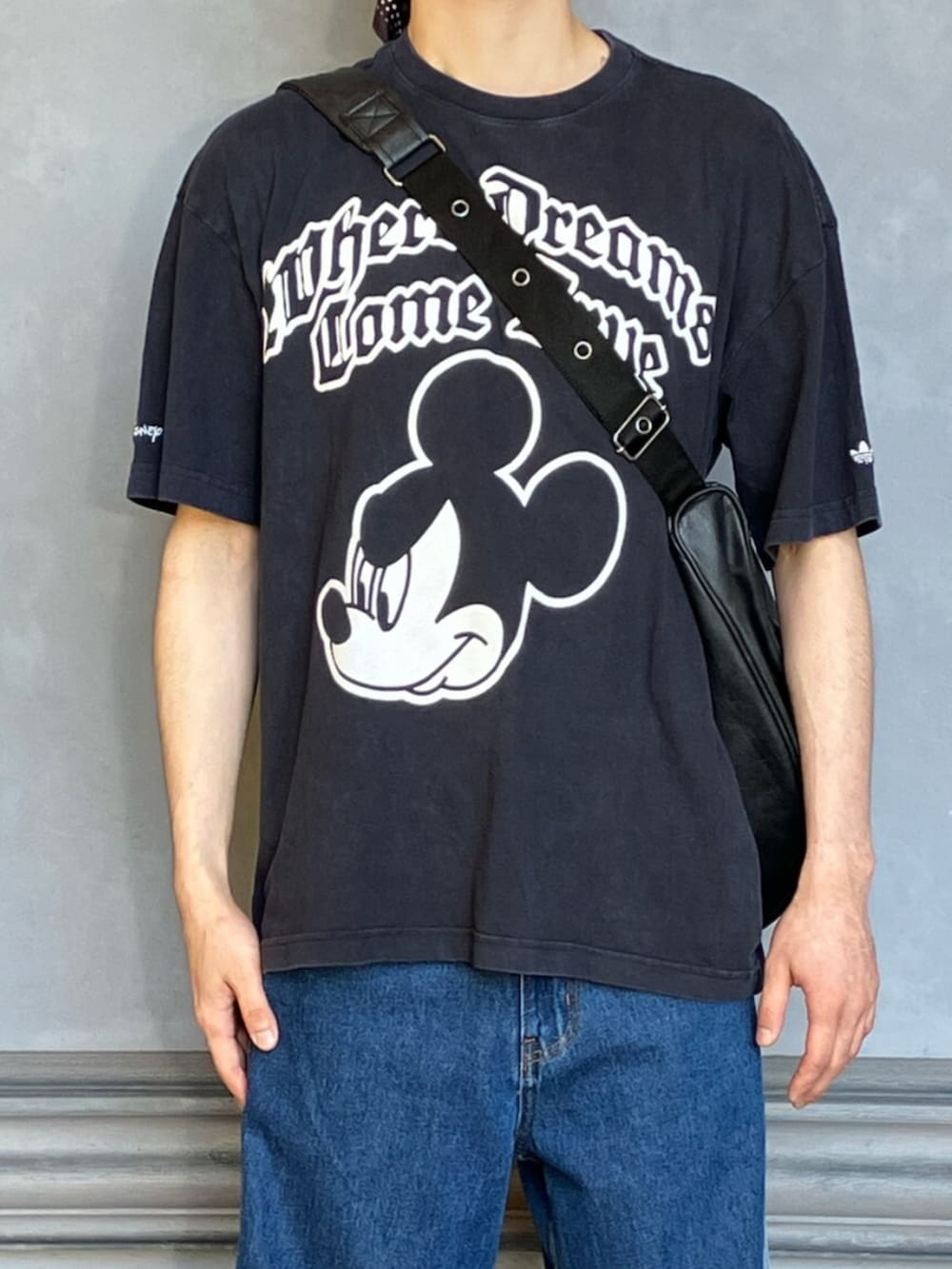 ブラック系のTシャツ/カットソー、ブルー系のデニムパンツ、ホワイト系のシューズを着用したメンズの夏コーディネートの3枚目の写真
