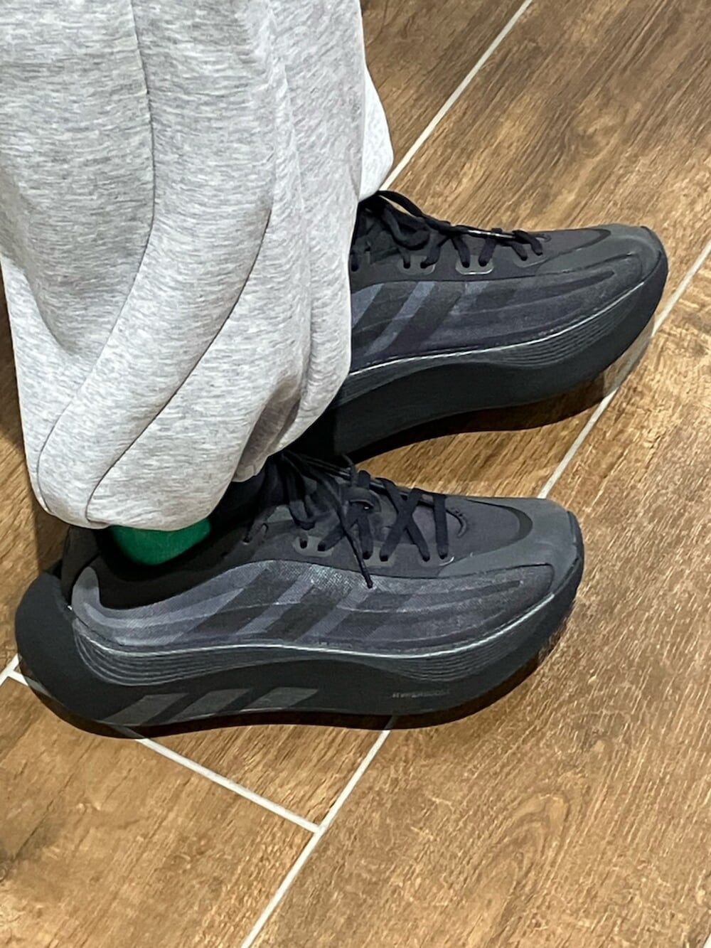 グレー系のパーカー、グレー系のスウェットパンツ、ブラック系のエコバッグ/サブバッグを着用したメンズの秋コーディネートの6枚目の写真