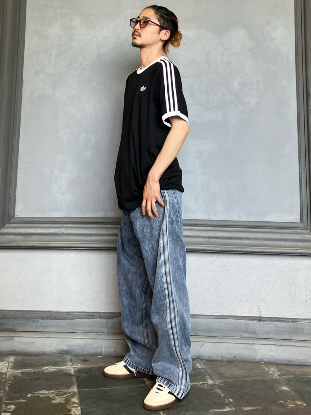 ブラック系のTシャツ/カットソー、ブルー系のデニムパンツ、ホワイト系のスニーカーを着用したメンズの秋コーディネートの2枚目の写真