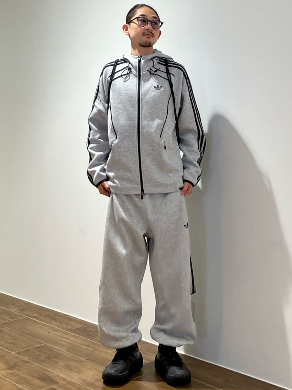 グレー系のパーカー、グレー系のスウェットパンツ、ブラック系のエコバッグ/サブバッグを着用したメンズの秋コーディネートの2枚目の写真