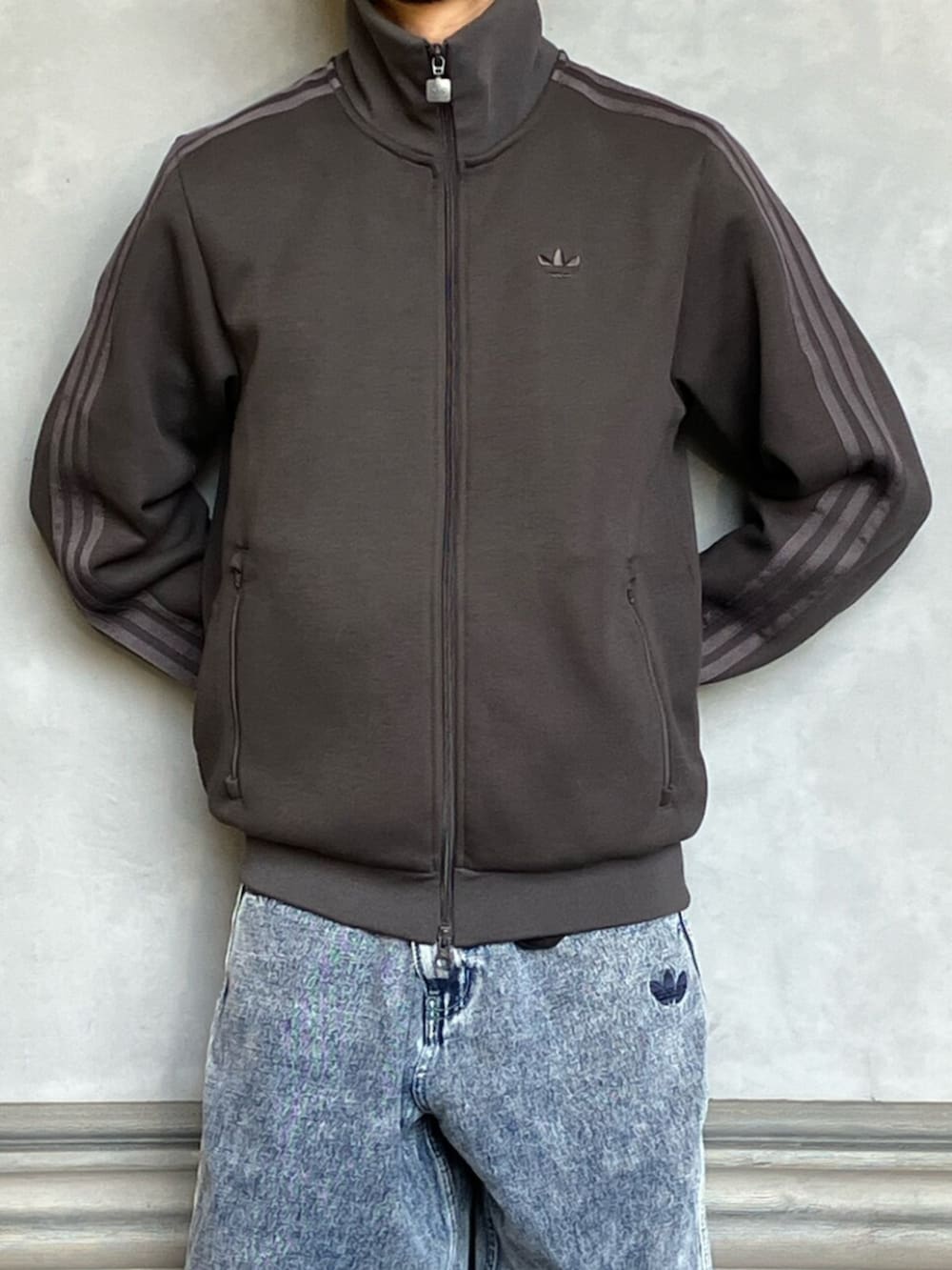 ブルー系のデニムパンツ、ブラック系のトップス、ブラウン系のスニーカーを着用したメンズの秋コーディネートの3枚目の写真