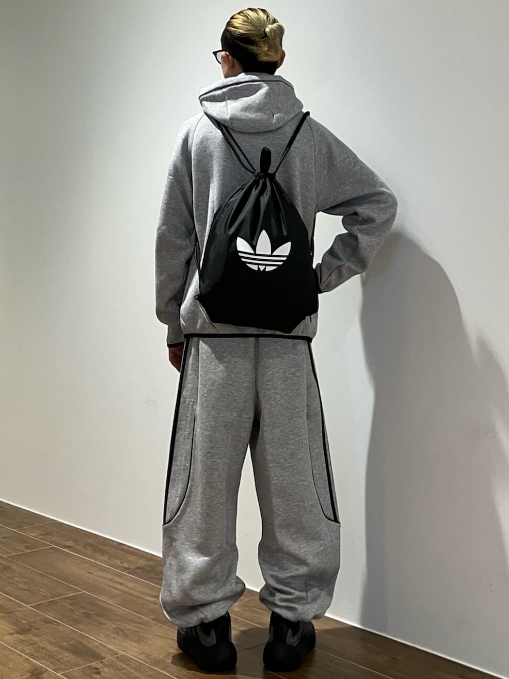 グレー系のパーカー、グレー系のスウェットパンツ、ブラック系のエコバッグ/サブバッグを着用したメンズの秋コーディネートの3枚目の写真