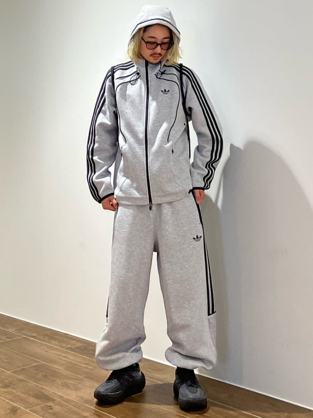 グレー系のパーカー、グレー系のスウェットパンツ、ブラック系のエコバッグ/サブバッグを着用したメンズの秋コーディネートの4枚目の写真