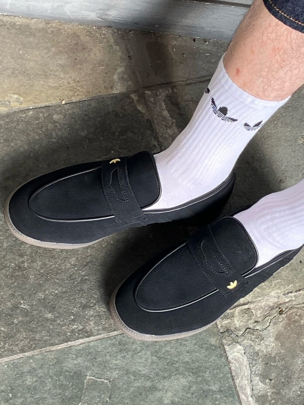 ホワイト系のポロシャツ、ブルー系のデニムパンツ、ブラック系のローファーを着用したメンズの夏コーディネートの4枚目の写真