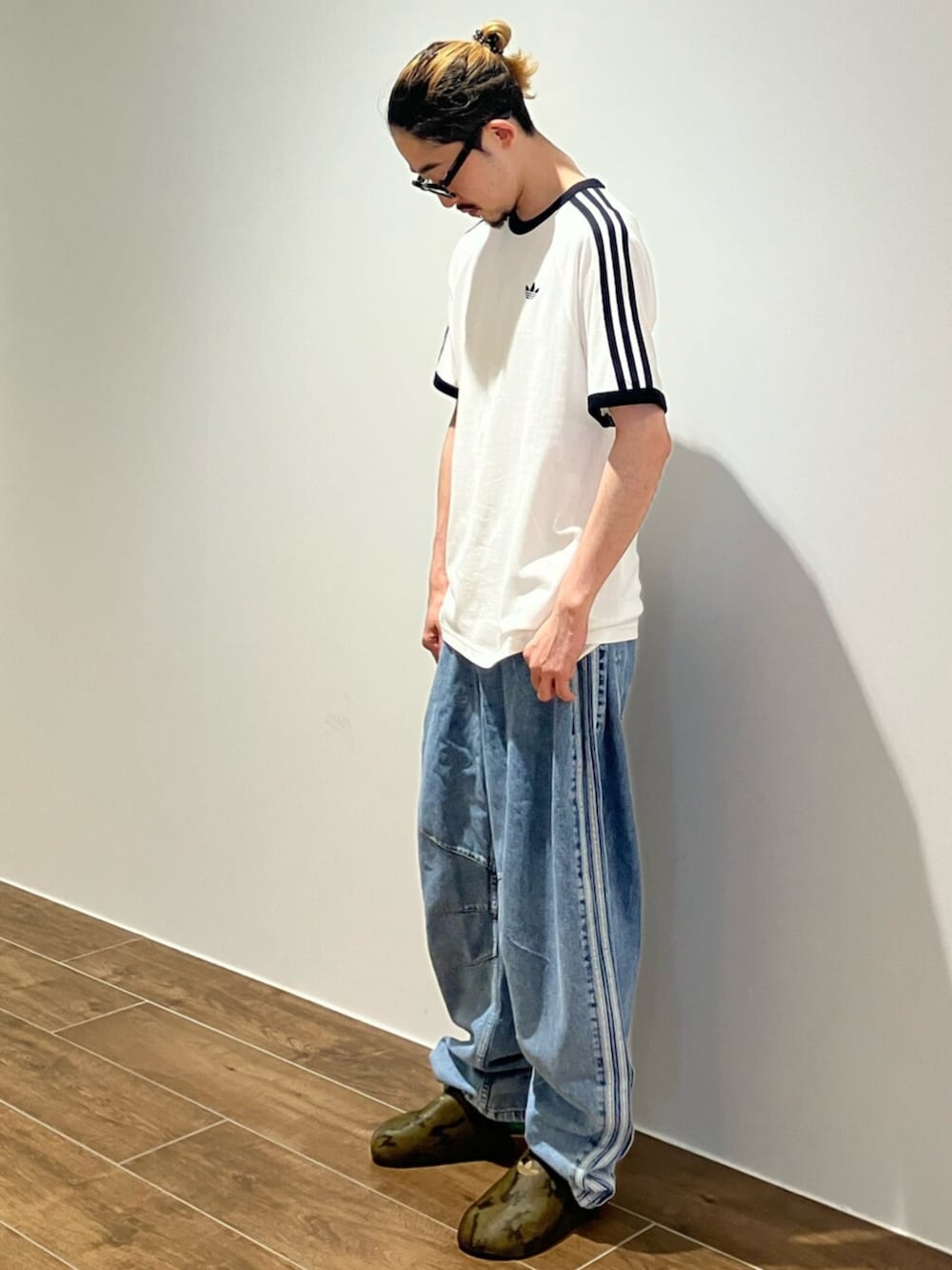 ブラック系のサンダル、ホワイト系のTシャツ/カットソー、ブルー系のデニムパンツを着用したメンズの夏コーディネートの2枚目の写真