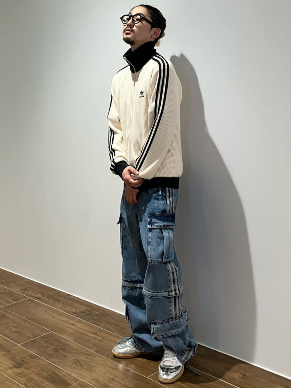 シルバー系のスニーカー、ホワイト系のジャージ、ブルー系のデニムパンツを着用したメンズの夏コーディネートの2枚目の写真