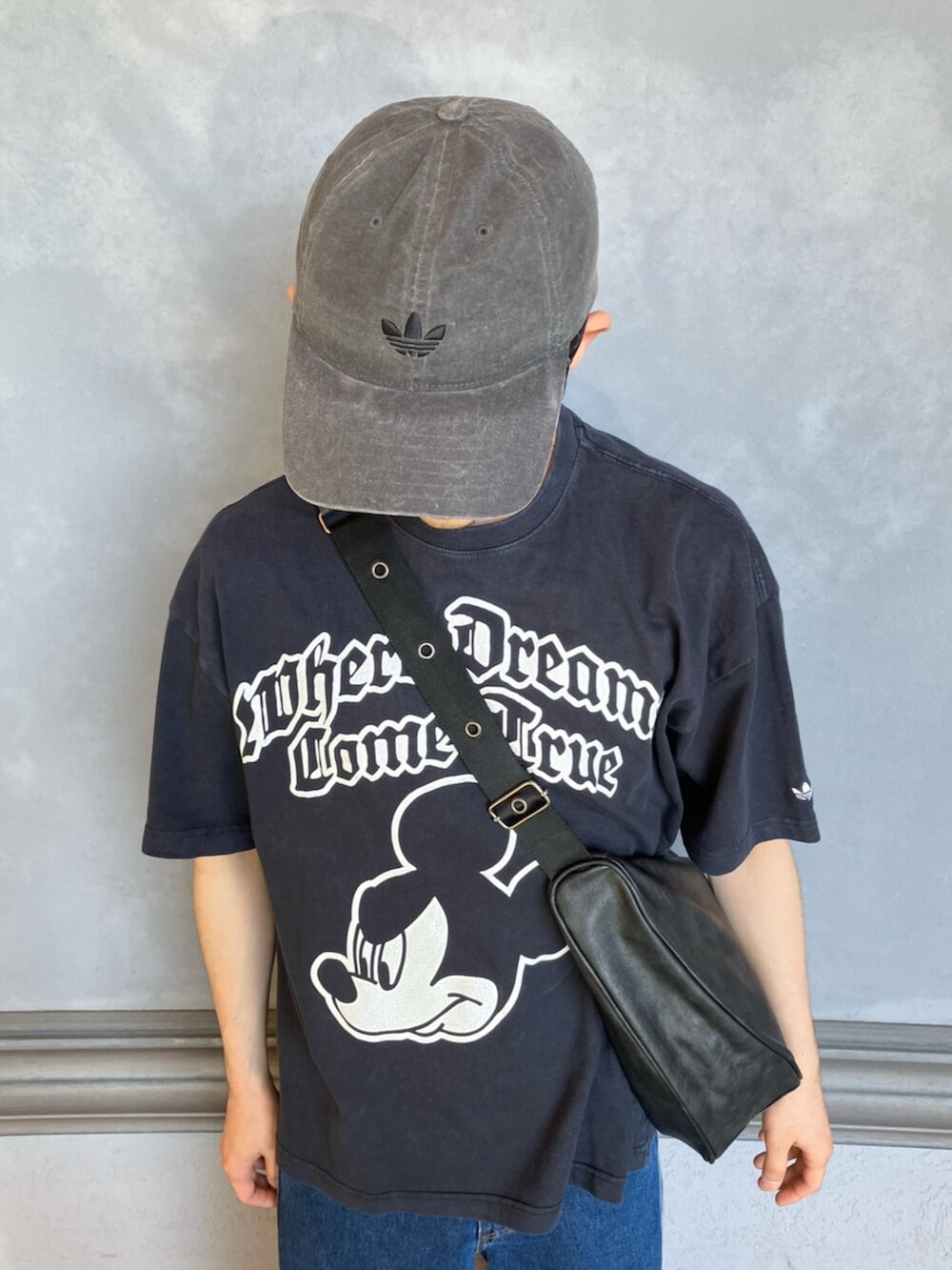 ブラック系のTシャツ/カットソー、ブルー系のデニムパンツ、ホワイト系のシューズを着用したメンズの夏コーディネートの6枚目の写真