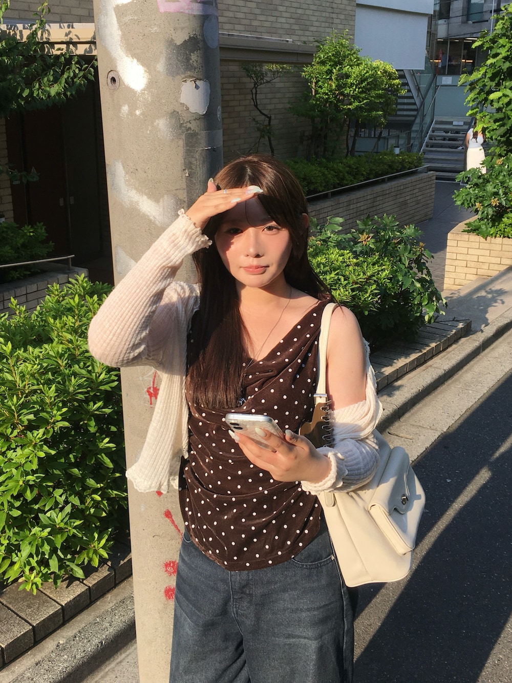 ブラウン系のタンクトップ、ホワイト系のバッグ、シルバー系のネックレスを着用したレディースの夏コーディネートの3枚目の写真