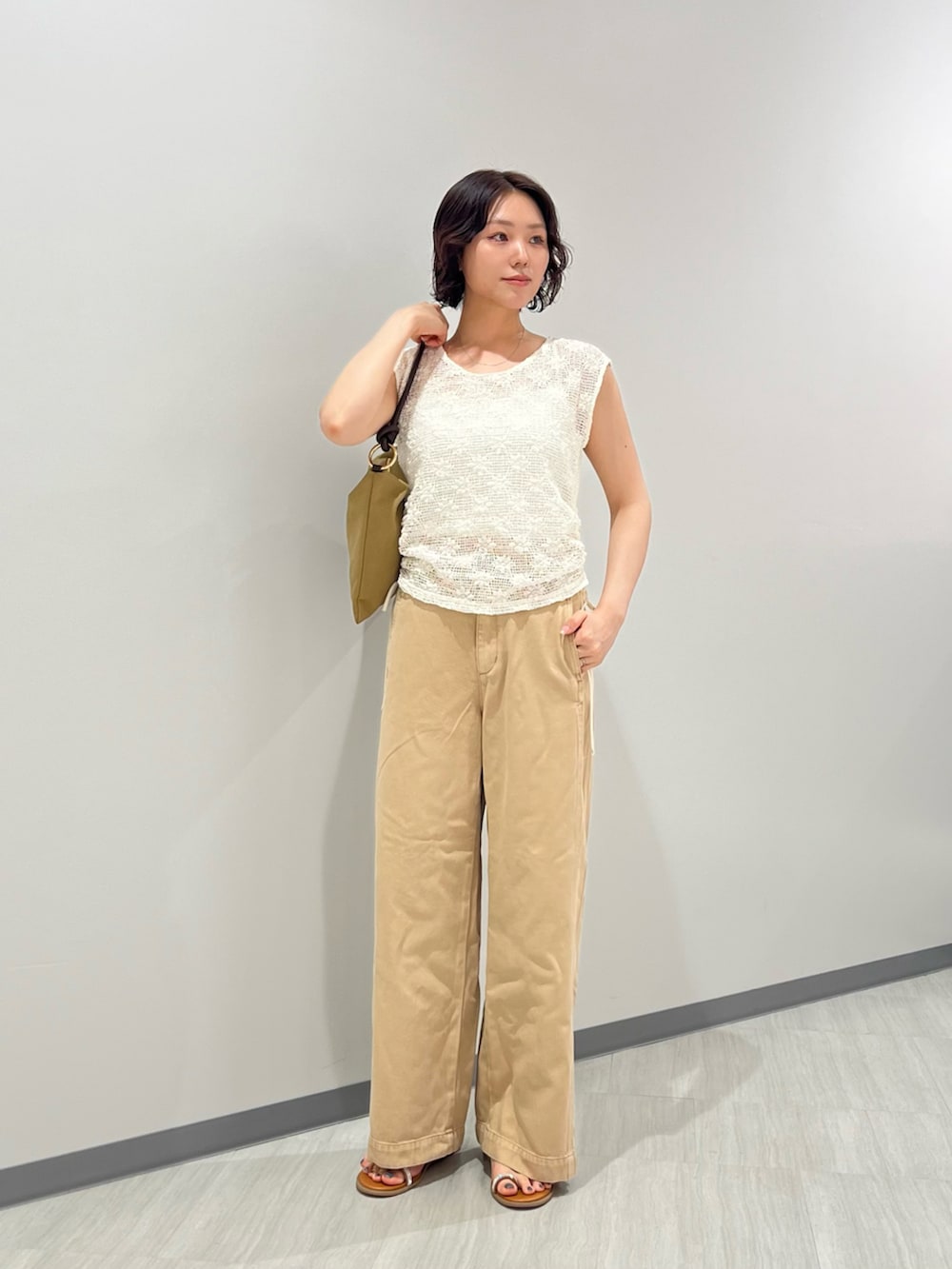 ホワイト系のTシャツ/カットソー、ベージュ系のパンツ、ベージュ系のショルダーバッグを着用したレディースの夏コーディネートの2枚目の写真