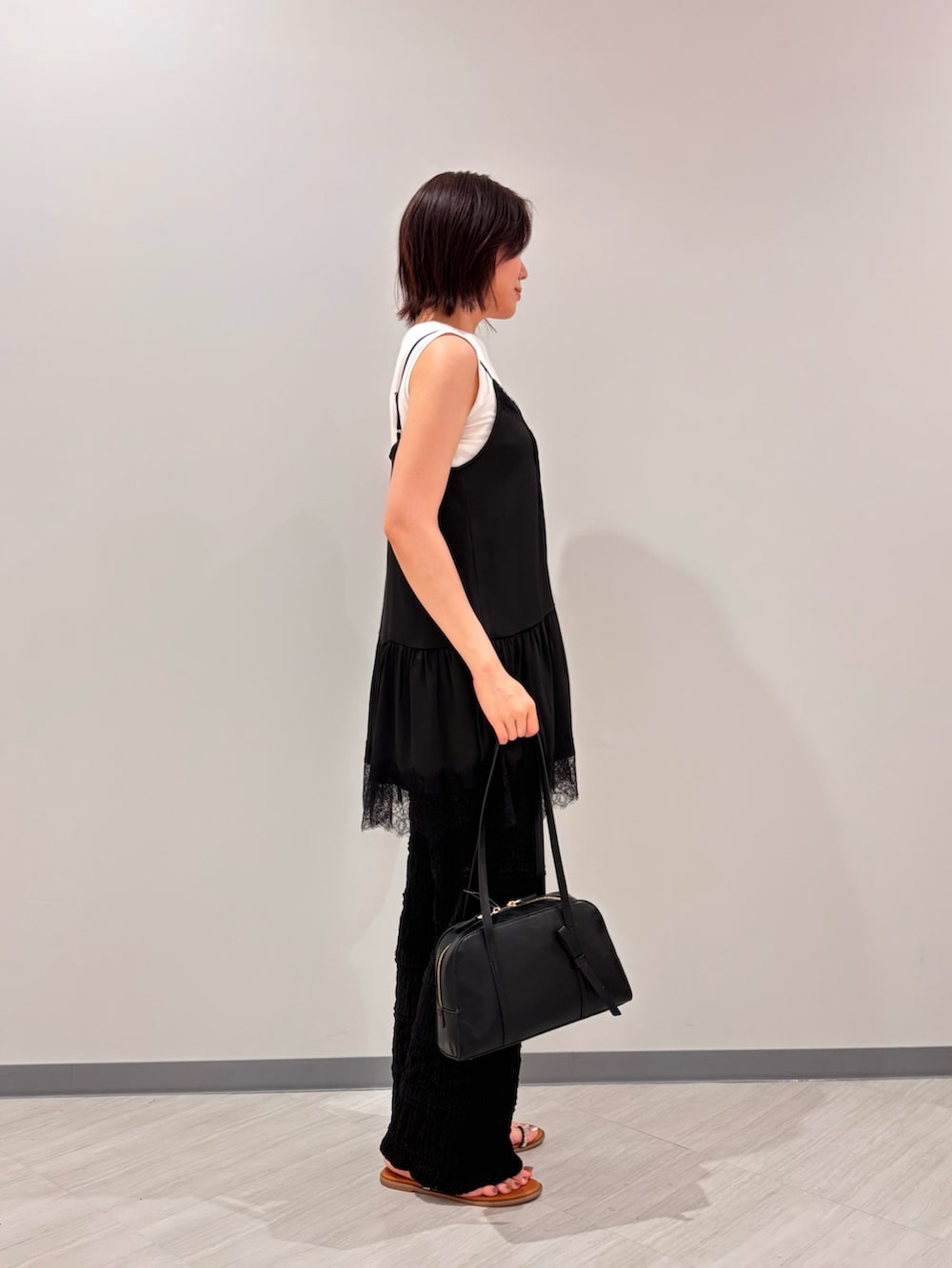 ブラック系のキャミソール、ブラック系のその他パンツ、イエロー系のサンダルを着用したレディースの夏コーディネートの3枚目の写真