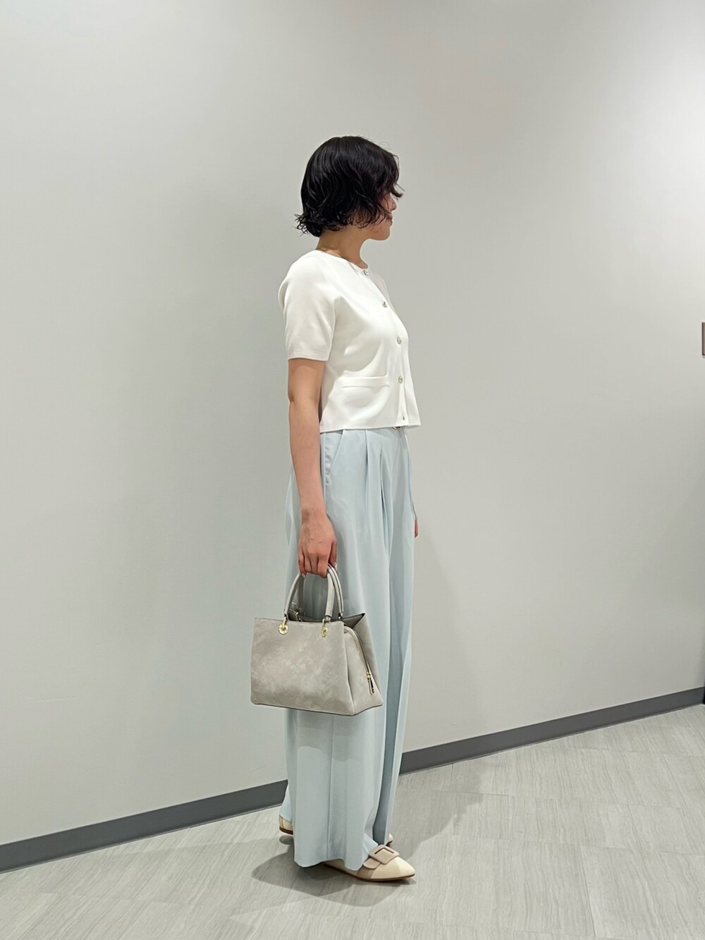 ホワイト系のパンプス、グレー系のトートバッグ、ホワイト系のカーディガン/ボレロを着用したレディースの夏コーディネートの2枚目の写真