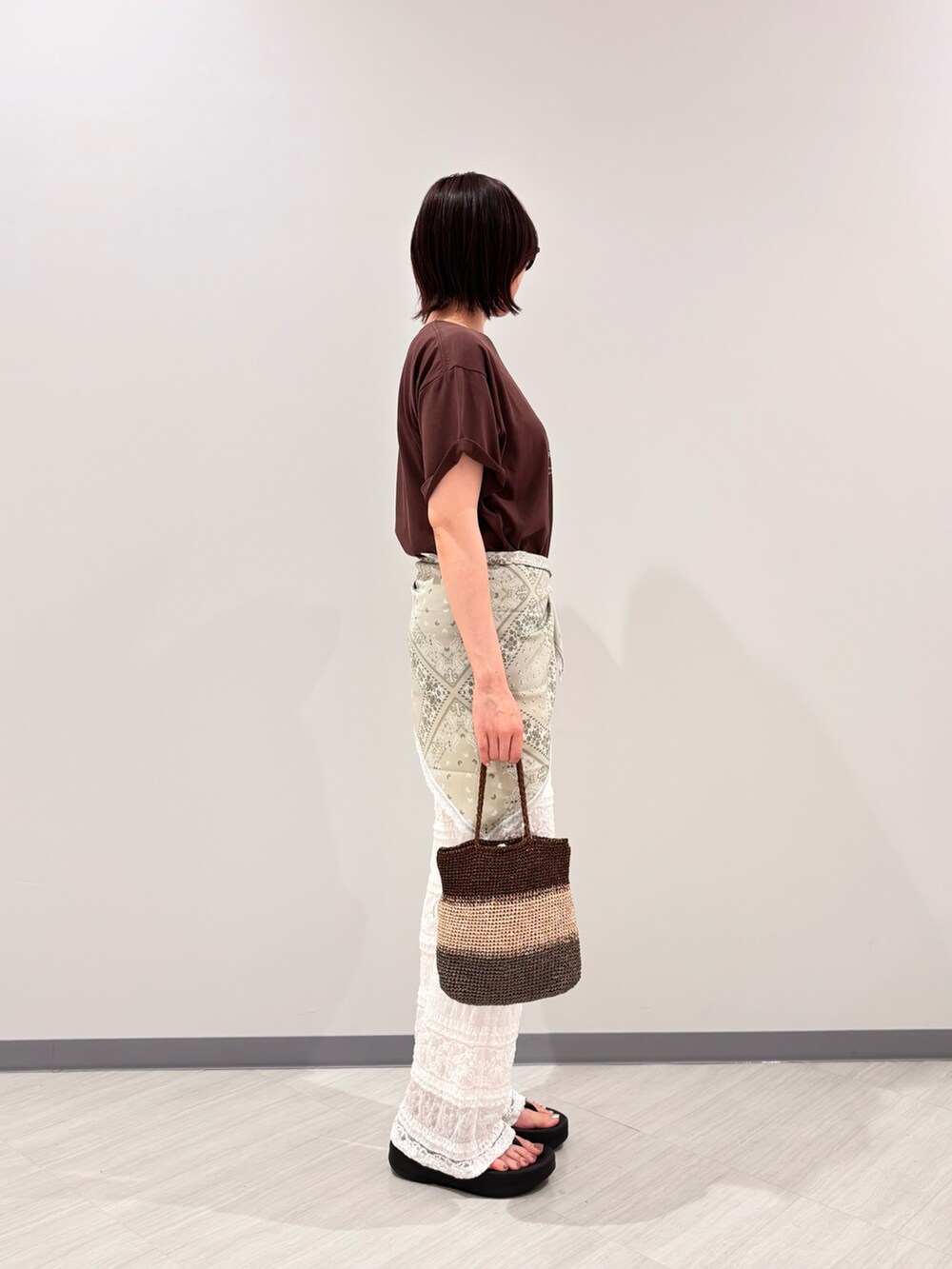 ブラウン系のTシャツ/カットソー、ホワイト系のその他パンツ、ゴールド系のハンドバッグを着用したレディースの夏コーディネートの3枚目の写真