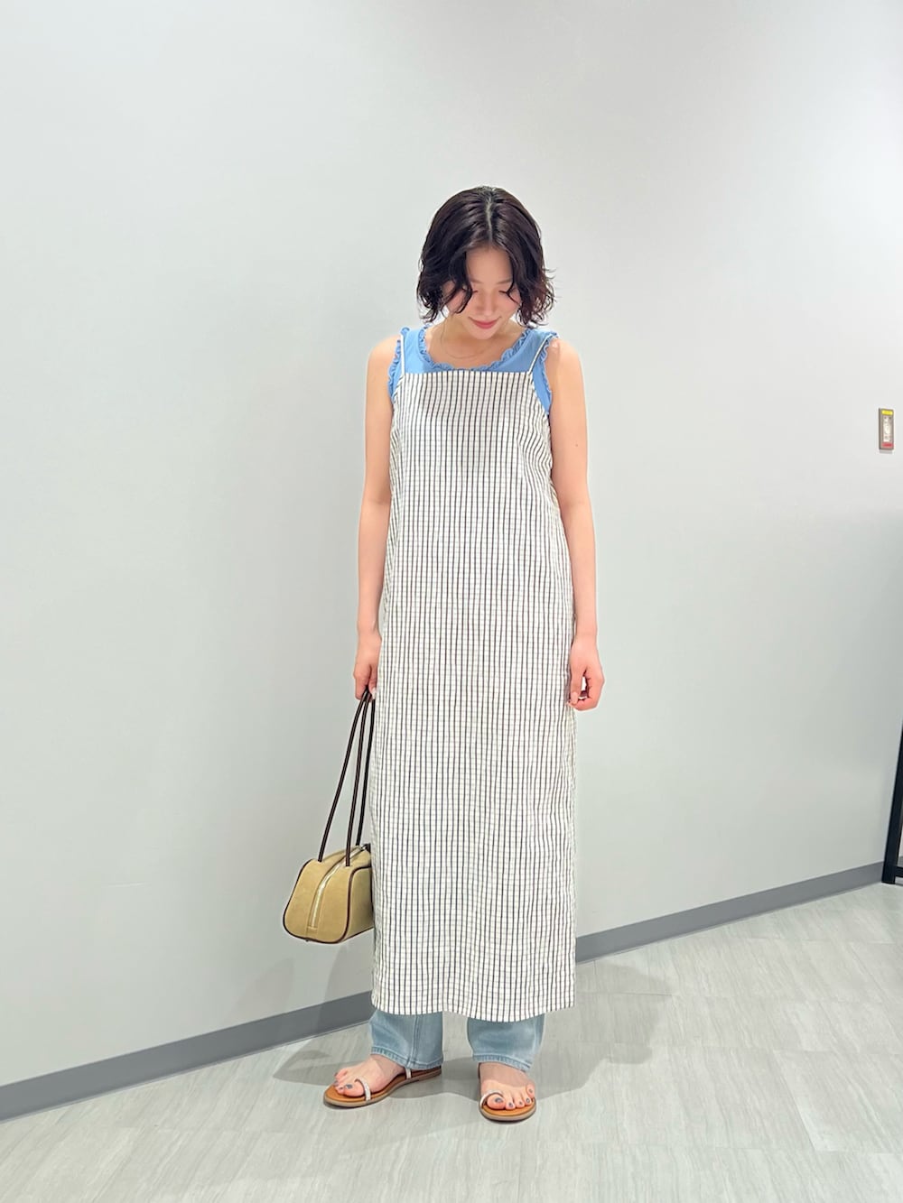 ブルー系のタンクトップ、ブルー系のデニムパンツ、ホワイト系のワンピースを着用したレディースの夏コーディネートの2枚目の写真