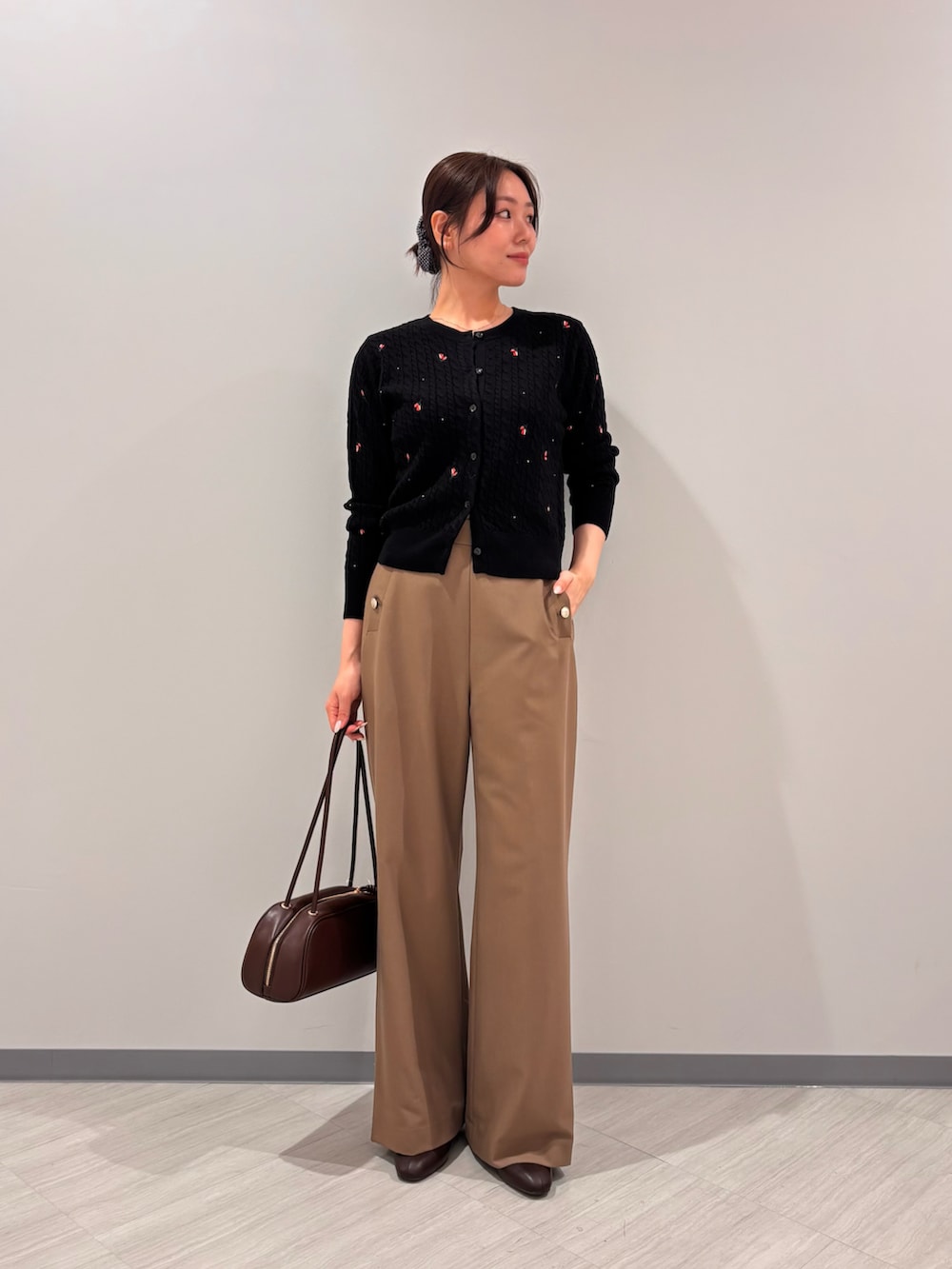 ブラック系のカーディガン/ボレロ、イエロー系のその他パンツ、ブラック系のボストンバッグを着用したレディースの秋コーディネートの4枚目の写真