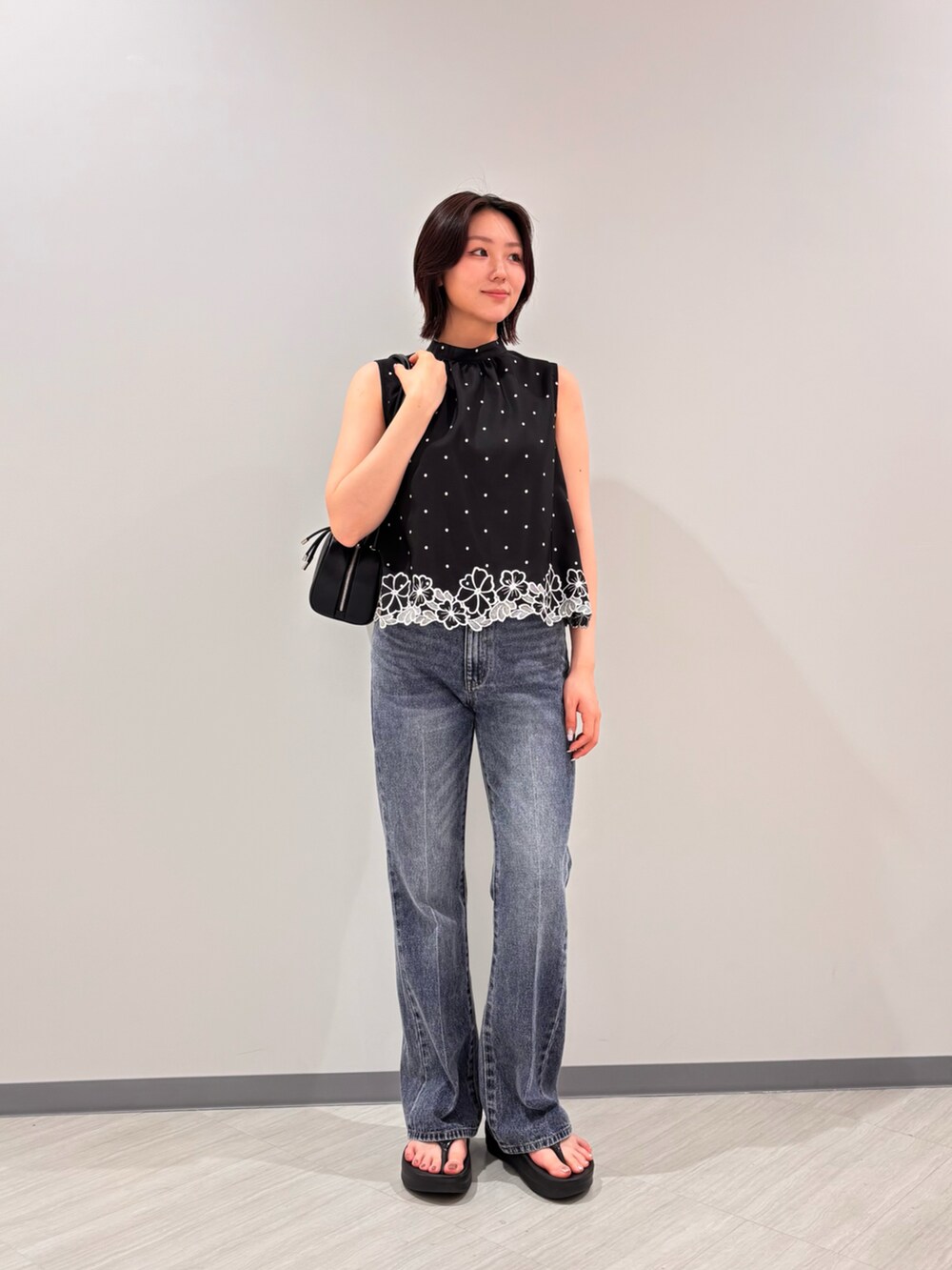 ブラック系のボストンバッグ、ブラック系のシャツ/ブラウス、ブラック系のサンダルを着用したレディースの夏コーディネートの2枚目の写真