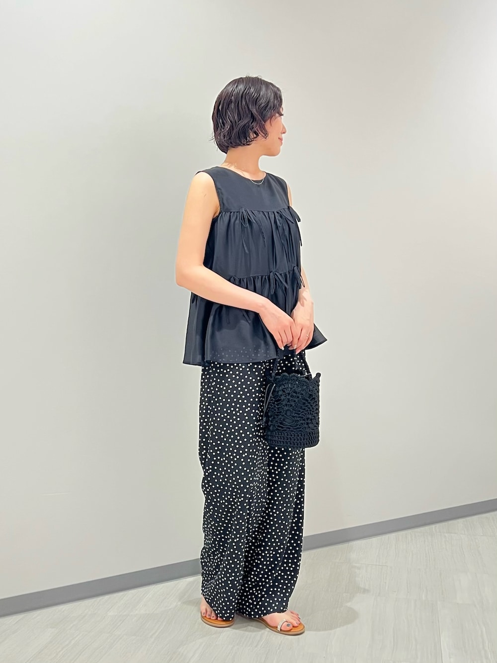 ブラック系のその他パンツ、ブラック系のハンドバッグ、イエロー系のサンダルを着用したレディースの夏コーディネートの3枚目の写真
