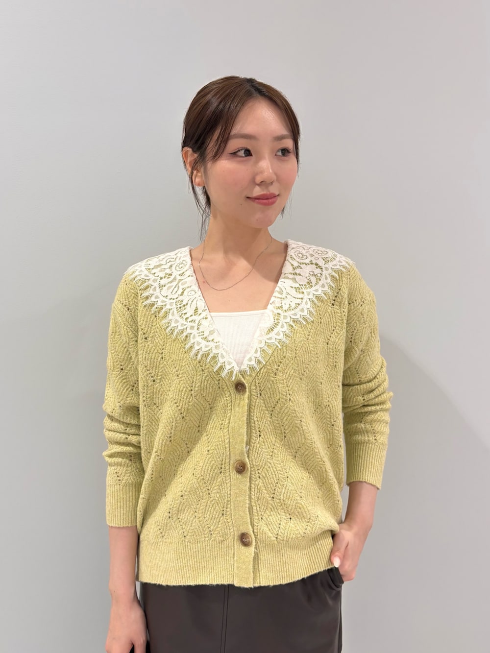 イエロー系のカーディガン/ボレロ、ブラウン系のスカート、ブラウン系のブーツを着用したレディースの秋コーディネートの4枚目の写真