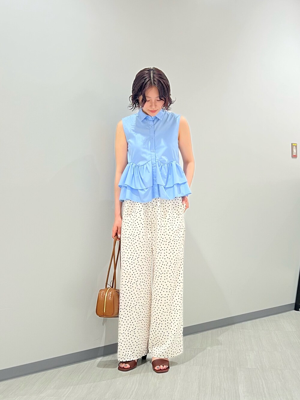 ブルー系のシャツ/ブラウス、ホワイト系のその他パンツ、ブラウン系のボストンバッグを着用したレディースの夏コーディネートの2枚目の写真