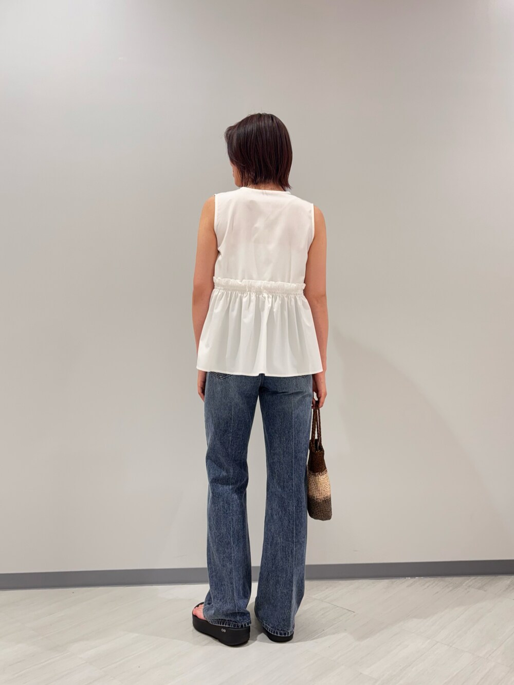 ホワイト系のシャツ/ブラウス、ブルー系のデニムパンツ、ゴールド系のハンドバッグを着用したレディースの夏コーディネートの4枚目の写真