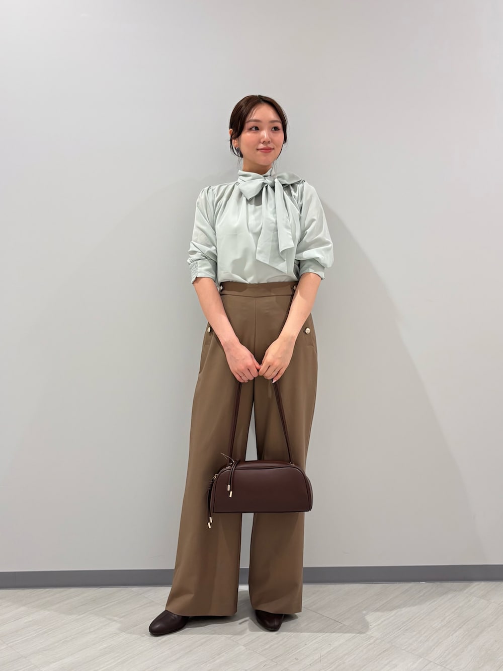 グリーン系のシャツ/ブラウス、イエロー系のその他パンツ、ブラック系のボストンバッグを着用したレディースの秋コーディネートの4枚目の写真