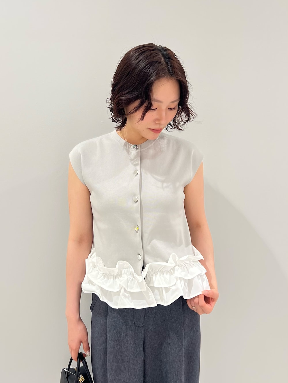 グレー系のベスト、ブルー系のその他パンツ、ブラック系のボストンバッグを着用したレディースの夏コーディネートの5枚目の写真