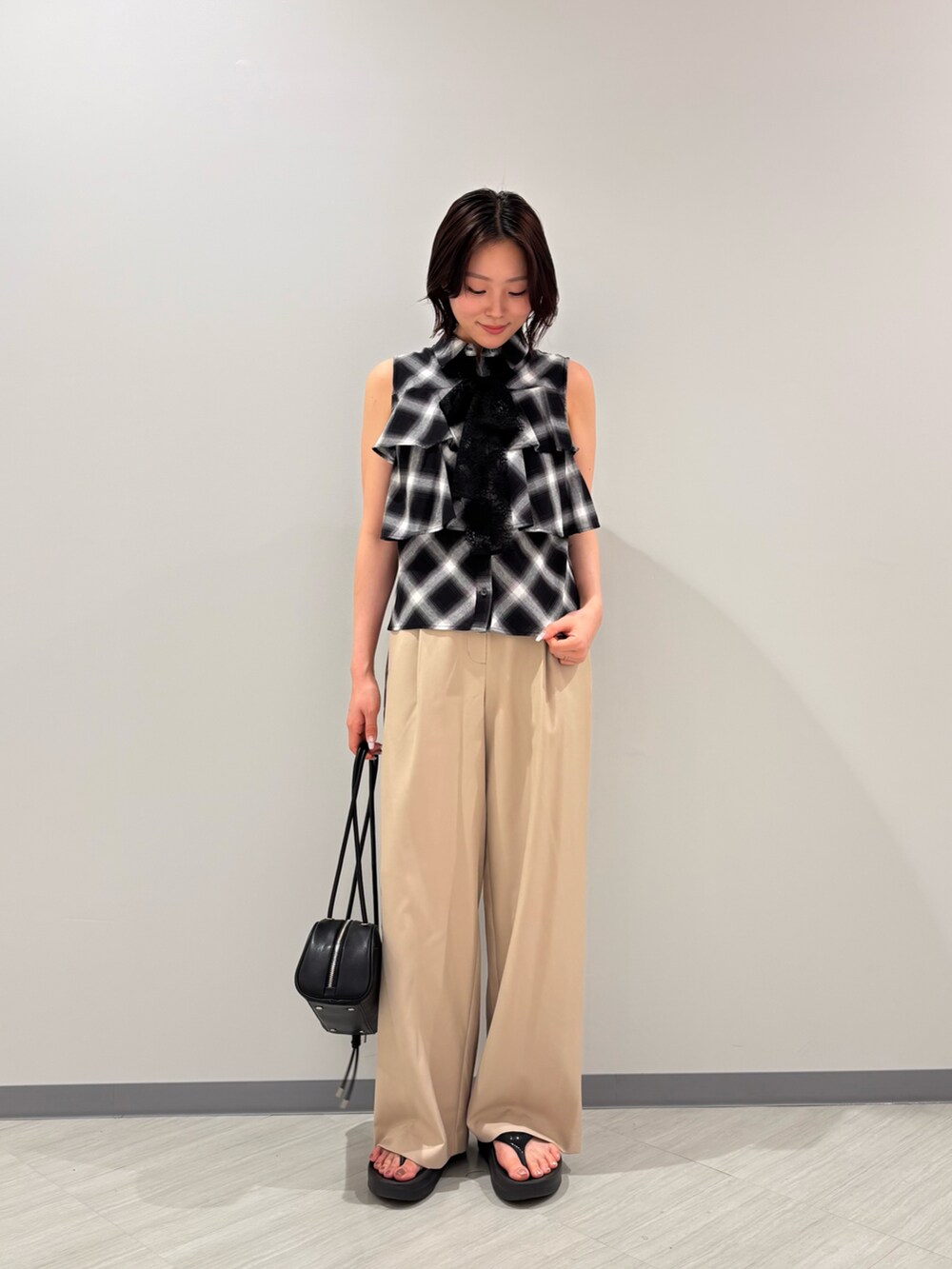 ブラック系のシャツ/ブラウス、ベージュ系のその他パンツ、ブラック系のボストンバッグを着用したレディースの夏コーディネートの3枚目の写真