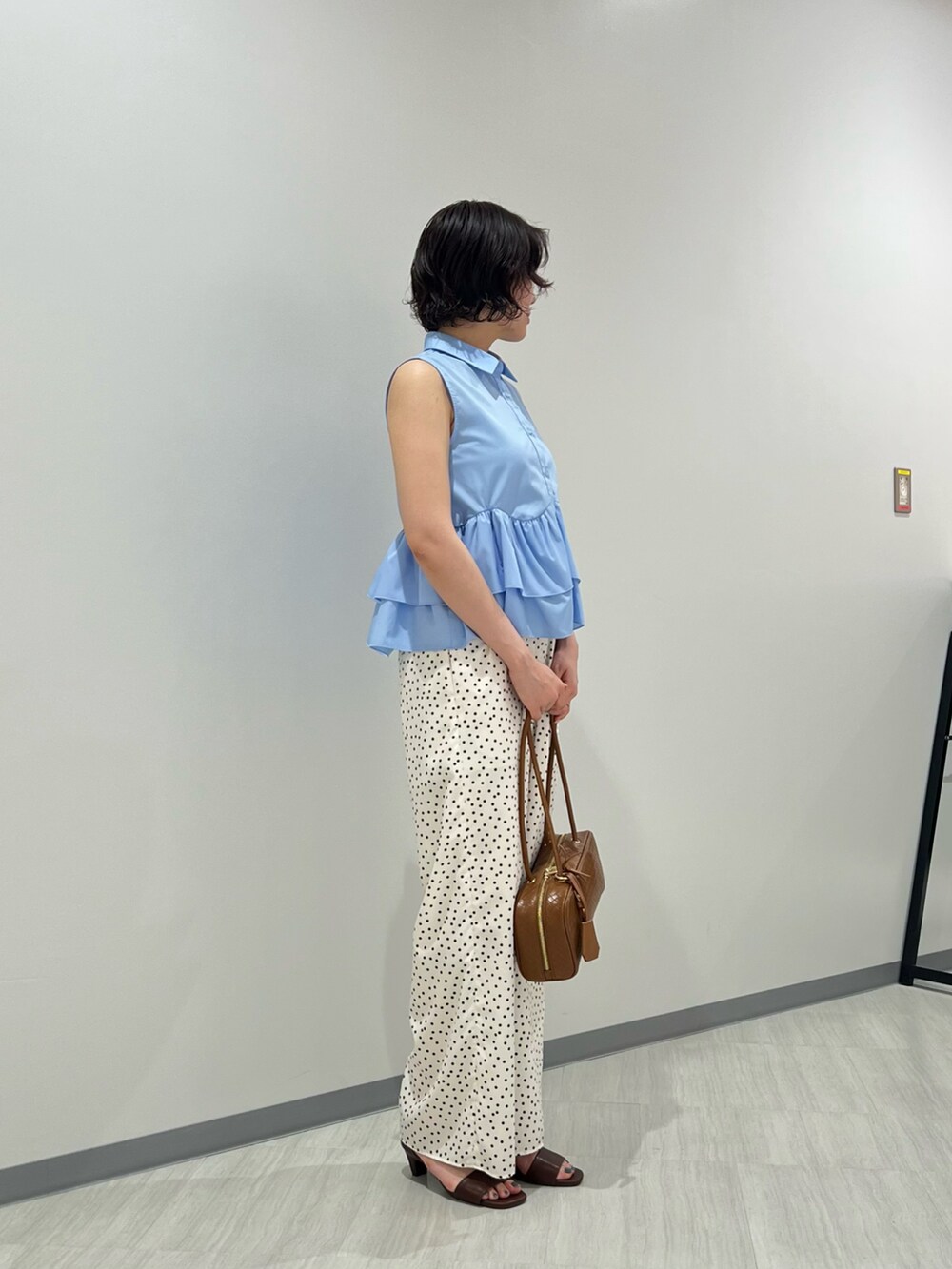 ブルー系のシャツ/ブラウス、ホワイト系のその他パンツ、ブラウン系のボストンバッグを着用したレディースの夏コーディネートの3枚目の写真