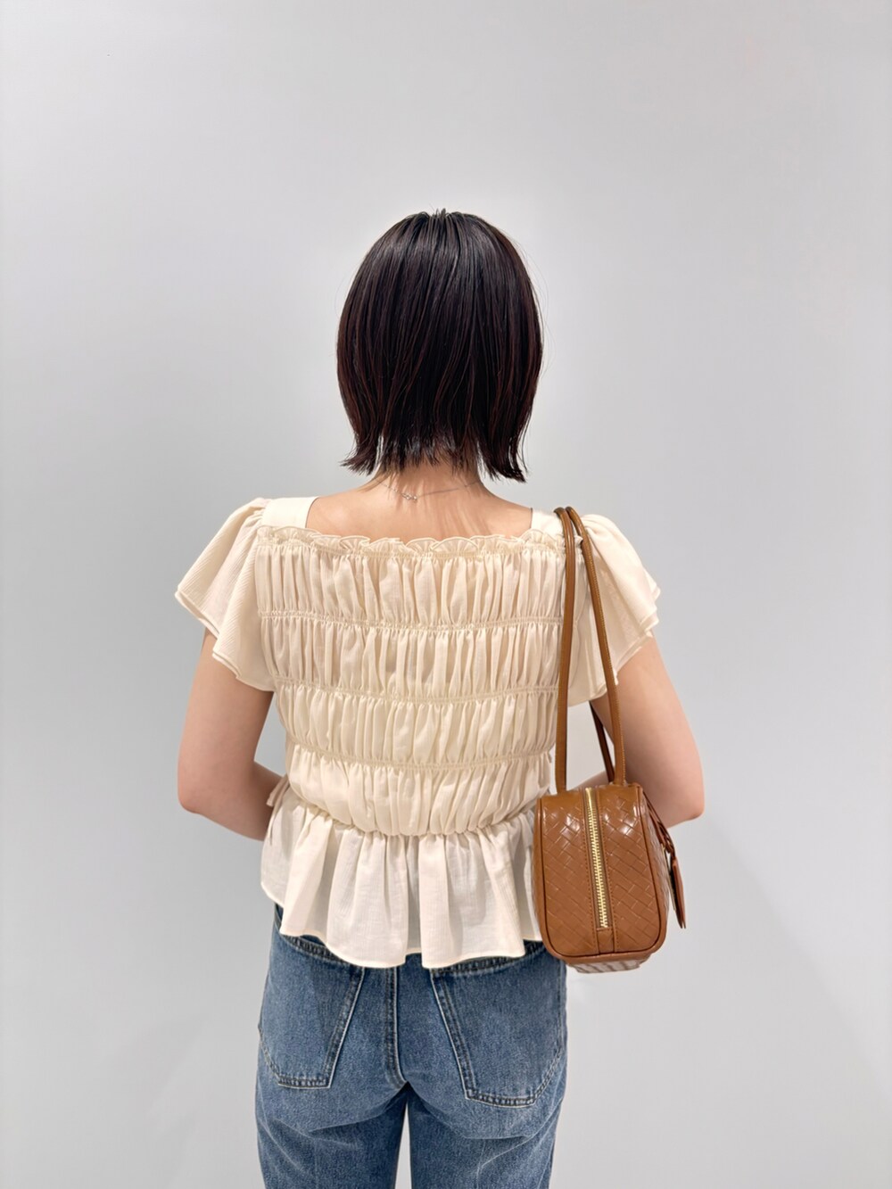 ホワイト系のシャツ/ブラウス、ブルー系のデニムパンツ、オレンジ系のボストンバッグを着用したレディースの夏コーディネートの5枚目の写真