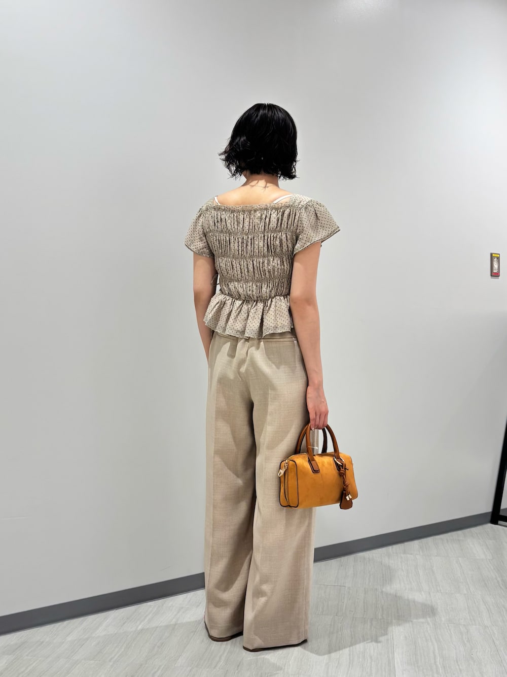 ベージュ系のシャツ/ブラウス、ベージュ系のその他パンツ、オレンジ系のボストンバッグを着用したレディースの夏コーディネートの4枚目の写真