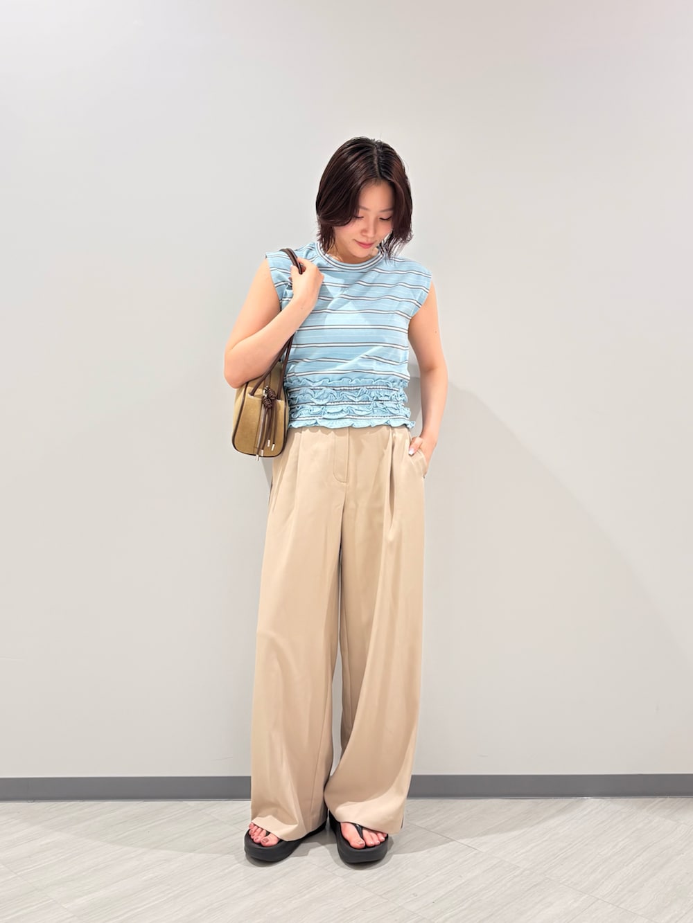 ブルー系のTシャツ/カットソー、ベージュ系のその他パンツ、ベージュ系のボストンバッグを着用したレディースの夏コーディネートの3枚目の写真