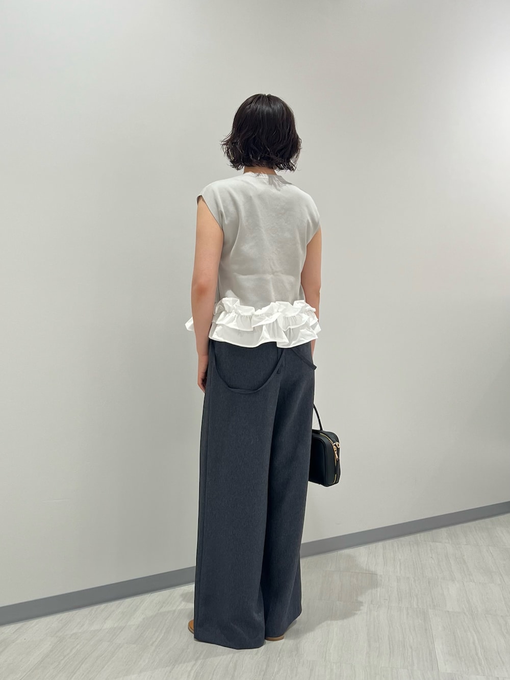 グレー系のベスト、ブルー系のその他パンツ、ブラック系のボストンバッグを着用したレディースの夏コーディネートの4枚目の写真