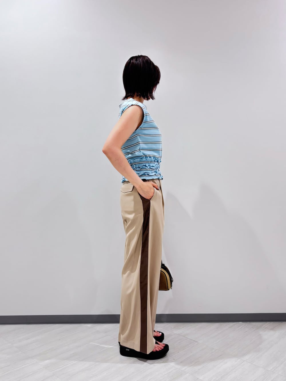 ブルー系のTシャツ/カットソー、ベージュ系のその他パンツ、ベージュ系のボストンバッグを着用したレディースの夏コーディネートの4枚目の写真
