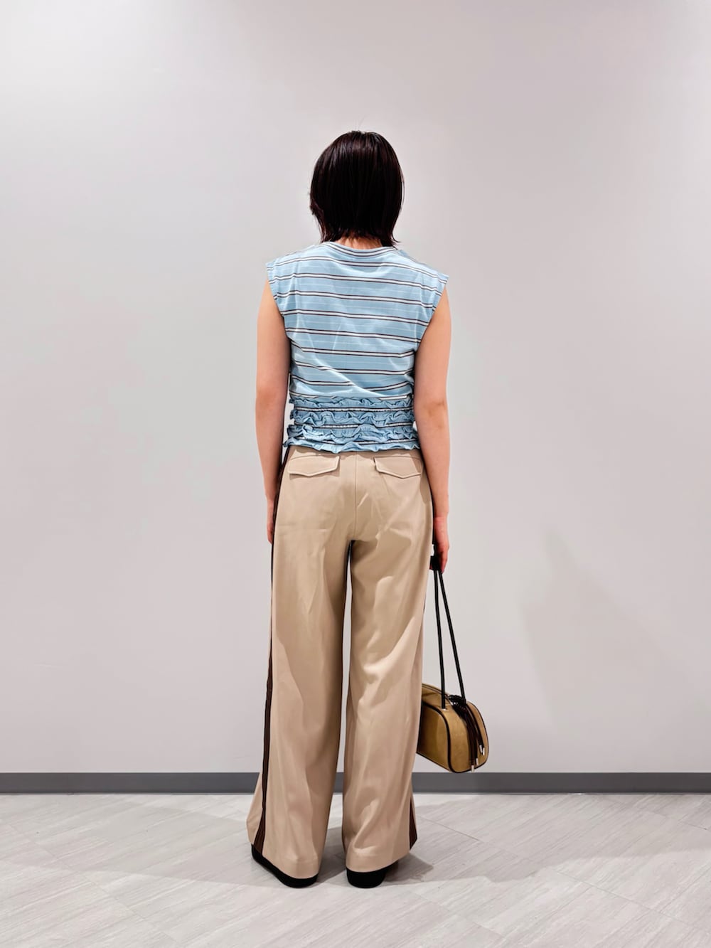 ブルー系のTシャツ/カットソー、ベージュ系のその他パンツ、ベージュ系のボストンバッグを着用したレディースの夏コーディネートの5枚目の写真