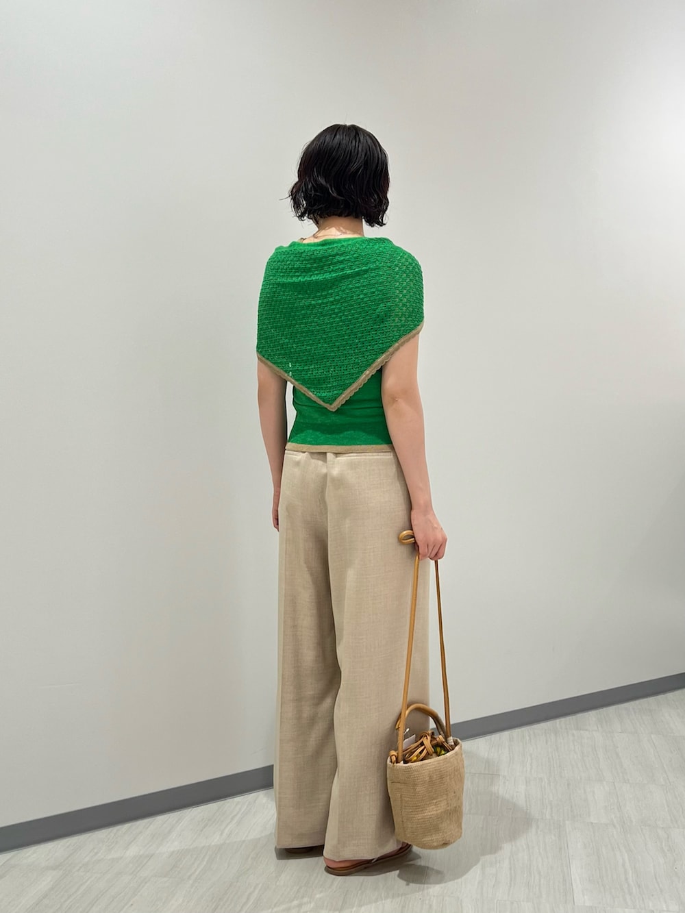 グリーン系のニット/セーター、ベージュ系のパンツ、ベージュ系のショルダーバッグを着用したレディースの夏コーディネートの4枚目の写真