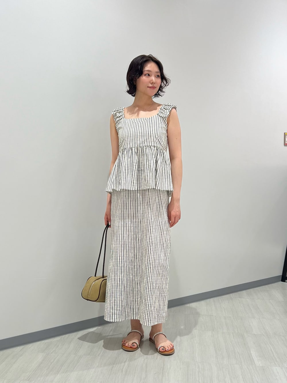 ホワイト系のシャツ/ブラウス、ホワイト系のワンピース、ベージュ系のボストンバッグを着用したレディースの夏コーディネートの2枚目の写真
