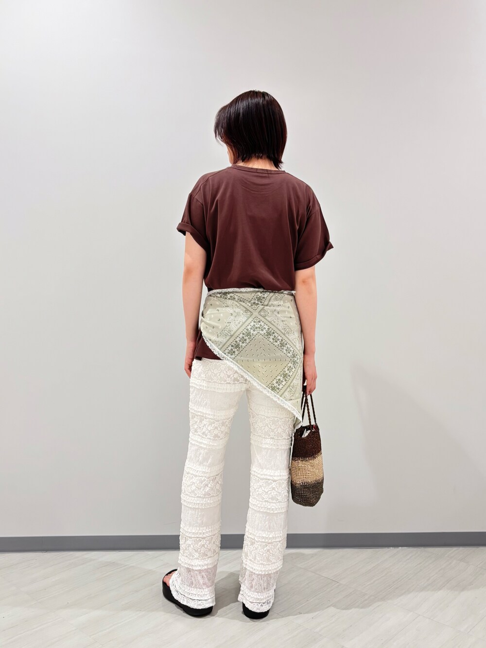 ブラウン系のTシャツ/カットソー、ホワイト系のその他パンツ、ゴールド系のハンドバッグを着用したレディースの夏コーディネートの4枚目の写真