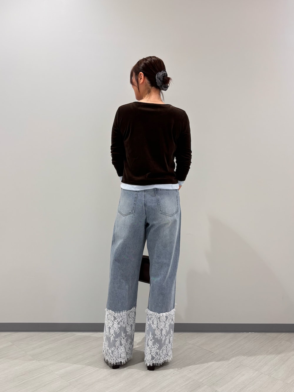 ブラウン系のTシャツ/カットソー、ブルー系のデニムパンツ、ブラック系のボストンバッグを着用したレディースの秋コーディネートの4枚目の写真