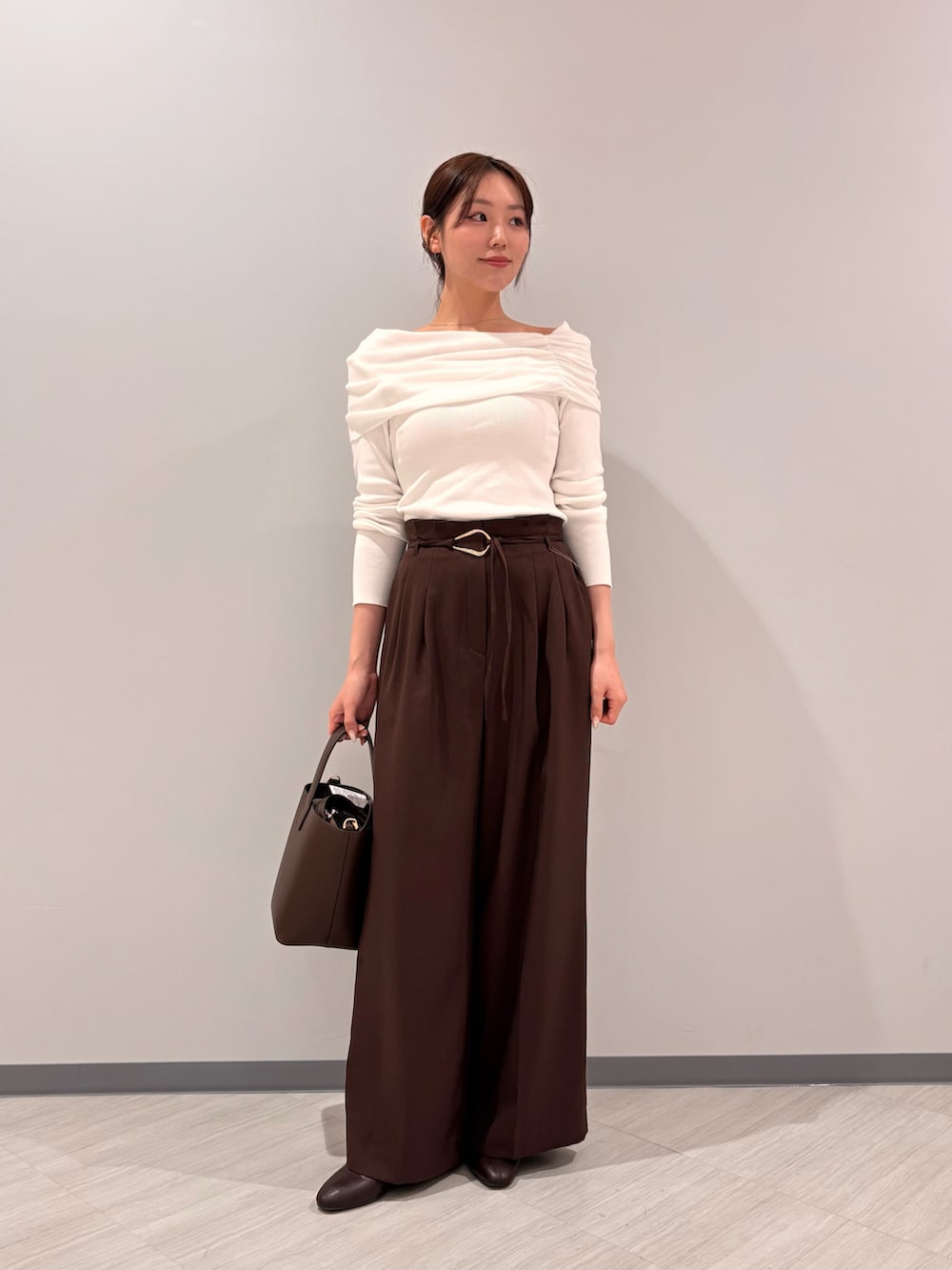 ホワイト系のニット/セーター、ブラウン系のその他パンツ、ブラウン系のブーツを着用したレディースの秋コーディネートの2枚目の写真