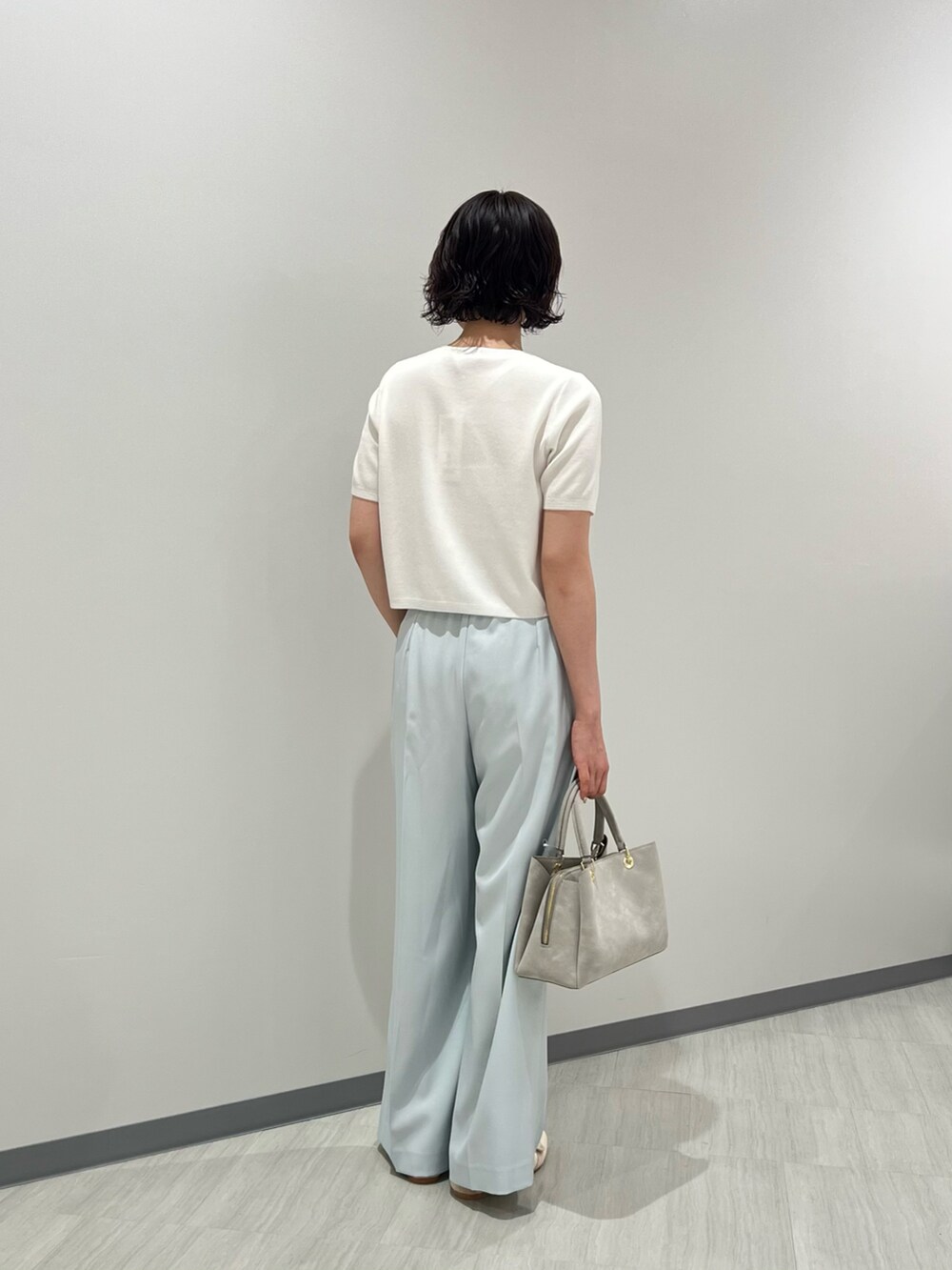 ホワイト系のパンプス、グレー系のトートバッグ、ホワイト系のカーディガン/ボレロを着用したレディースの夏コーディネートの3枚目の写真