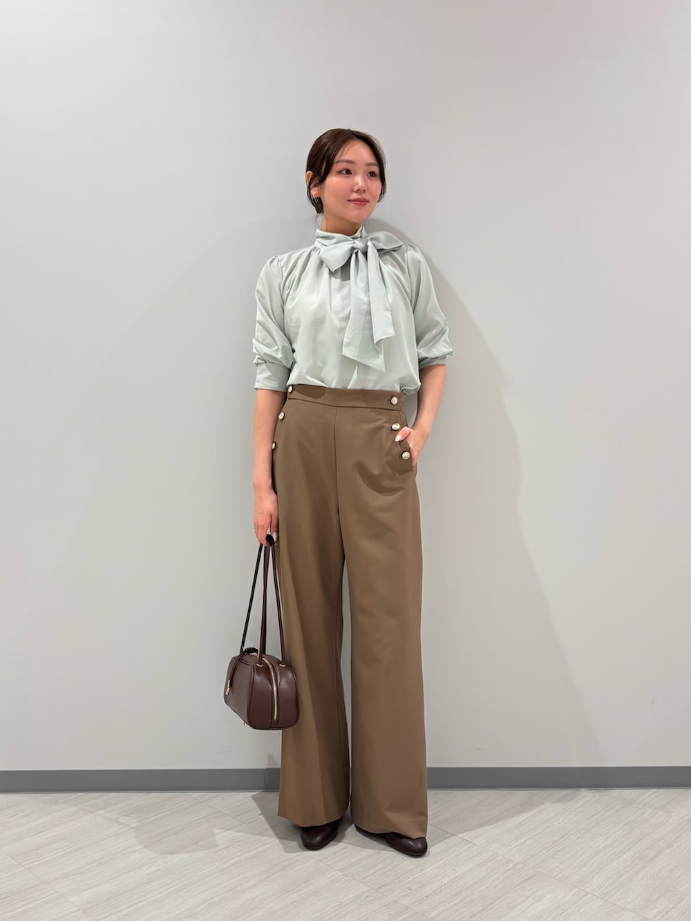 グリーン系のシャツ/ブラウス、イエロー系のその他パンツ、ブラック系のボストンバッグを着用したレディースの秋コーディネートの2枚目の写真