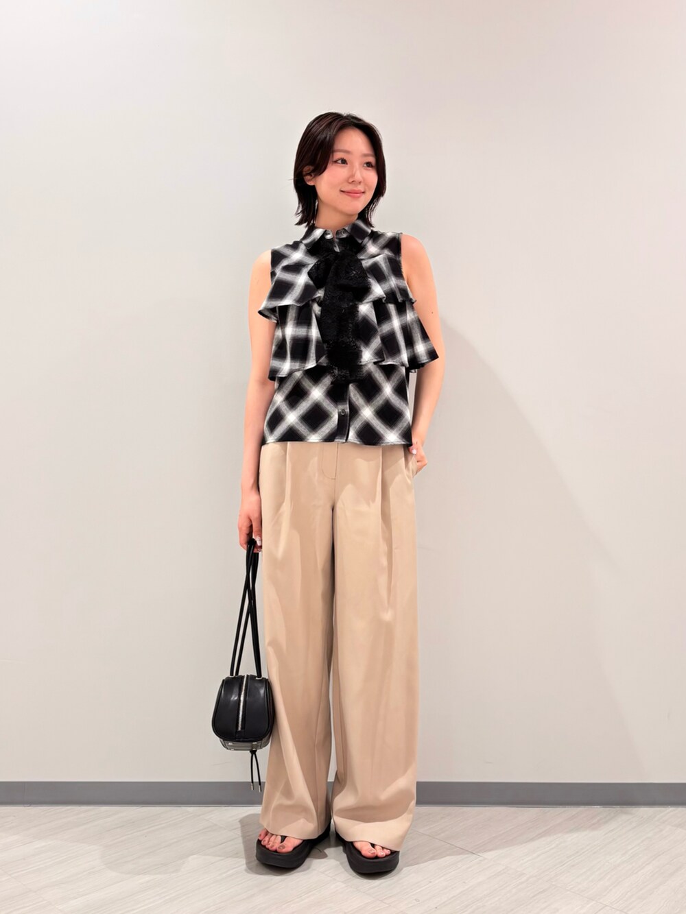 ブラック系のシャツ/ブラウス、ベージュ系のその他パンツ、ブラック系のボストンバッグを着用したレディースの夏コーディネートの2枚目の写真