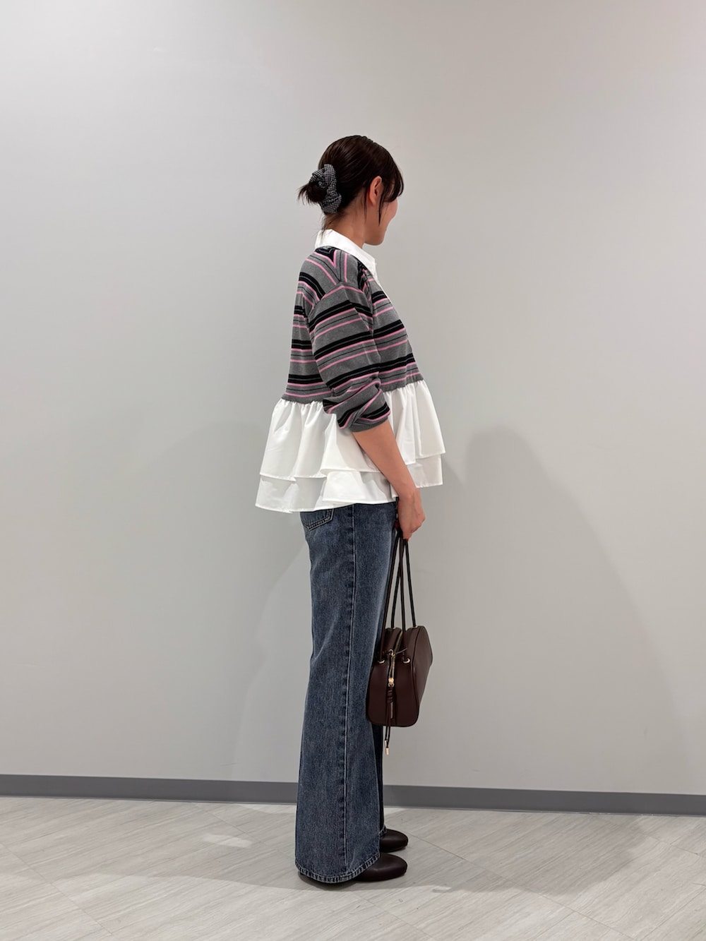 グレー系のニット/セーター、ブラウン系のブーツ、ブラック系のボストンバッグを着用したレディースの秋コーディネートの3枚目の写真