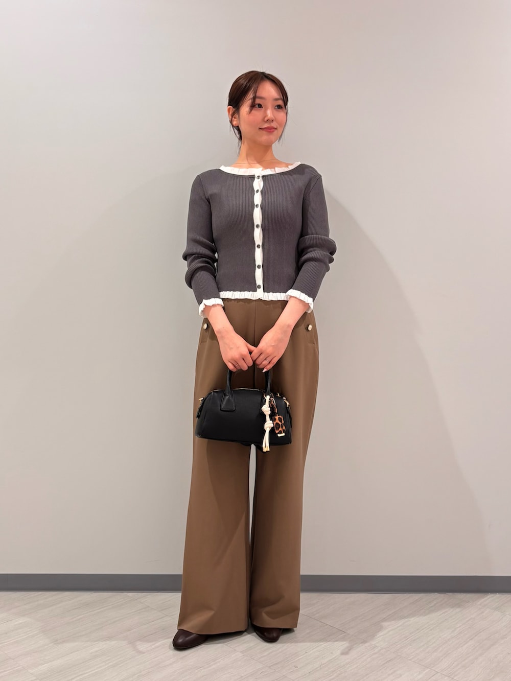 グレー系のカーディガン/ボレロ、イエロー系のその他パンツ、ブラウン系のブーツを着用したレディースの秋コーディネートの2枚目の写真