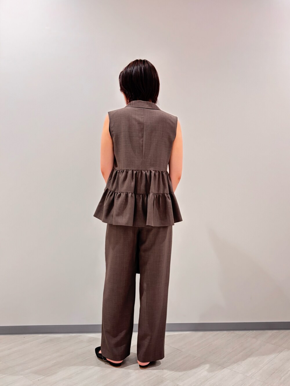 ブラック系のタンクトップ、ブルー系のベスト、ブラウン系のその他パンツを着用したレディースの夏コーディネートの3枚目の写真