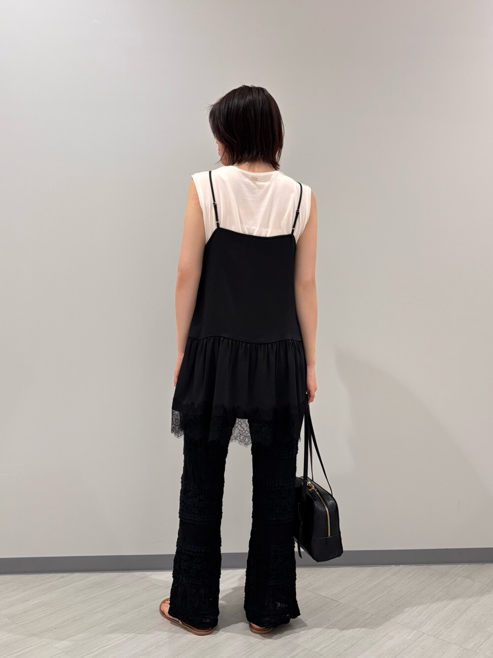 ブラック系のキャミソール、ブラック系のその他パンツ、イエロー系のサンダルを着用したレディースの夏コーディネートの4枚目の写真