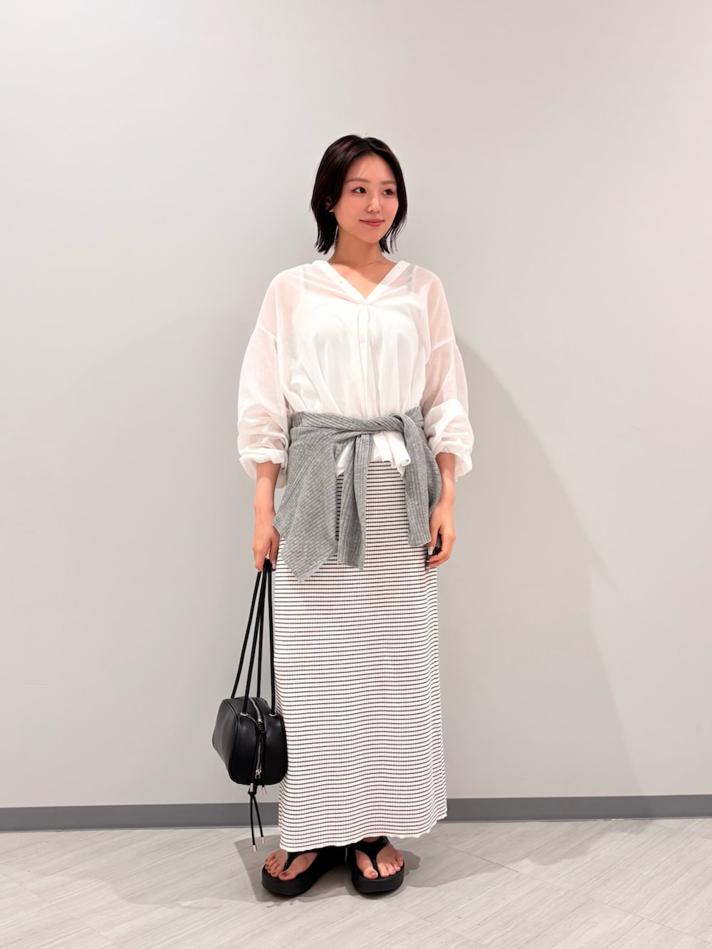 ホワイト系のシャツ/ブラウス、ホワイト系のワンピース、ブラック系のサンダルを着用したレディースの夏コーディネートの2枚目の写真